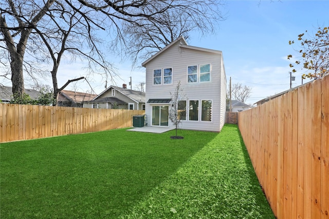 rear view of property with a lawn, central AC, and a patio area