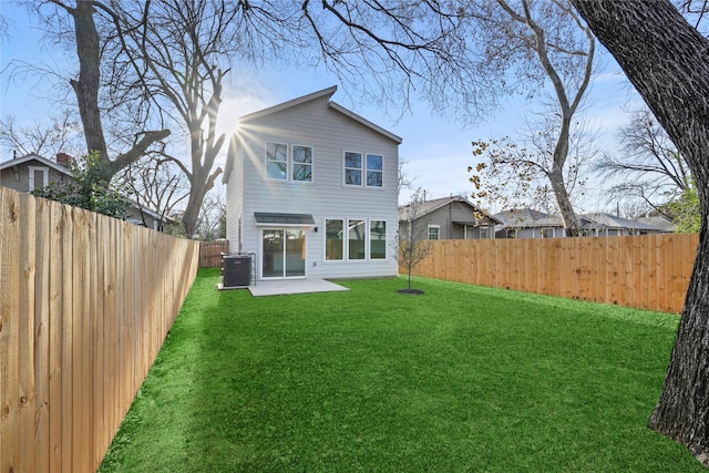 rear view of property featuring central air condition unit, a yard, and a patio