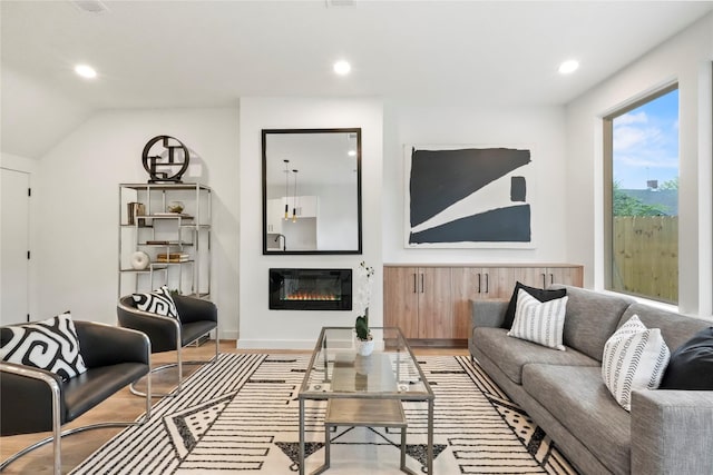 living room with vaulted ceiling and light hardwood / wood-style floors