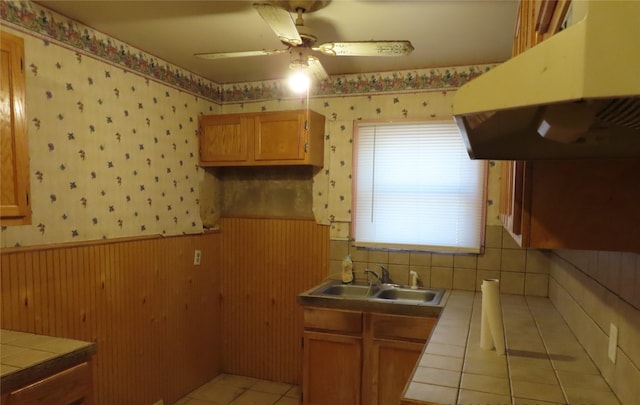 kitchen featuring sink, ceiling fan, tile countertops, and light tile patterned floors