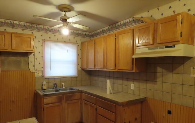 kitchen featuring tile countertops, ceiling fan, backsplash, and sink