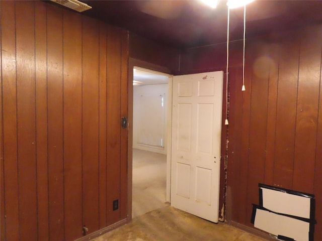 hallway featuring wood walls