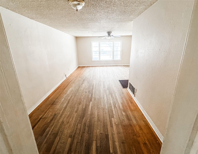 empty room with a textured ceiling and wood-type flooring