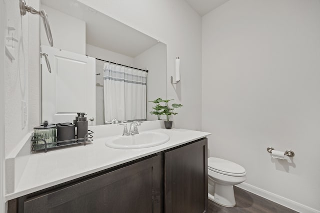 bathroom featuring hardwood / wood-style flooring, toilet, vanity, and a shower with shower curtain