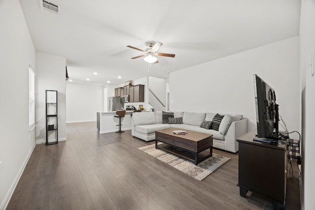 living room with dark hardwood / wood-style floors and ceiling fan