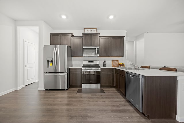 kitchen featuring sink, dark brown cabinets, stainless steel appliances, and dark hardwood / wood-style flooring