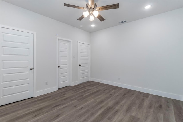 unfurnished bedroom featuring ceiling fan and dark hardwood / wood-style floors