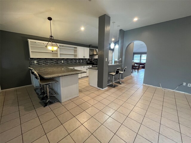 tiled living room featuring ceiling fan and vaulted ceiling