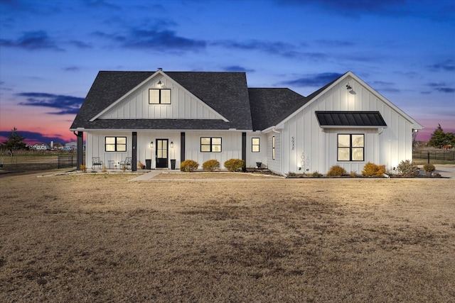 modern farmhouse style home featuring a yard and covered porch