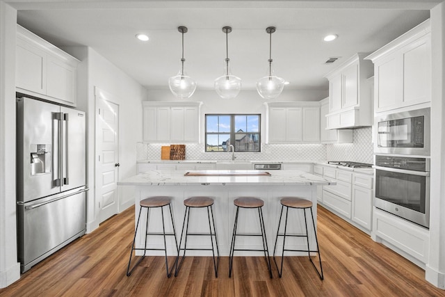 kitchen with white cabinets, pendant lighting, and appliances with stainless steel finishes