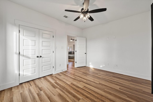 unfurnished bedroom with ceiling fan, light hardwood / wood-style flooring, and a closet