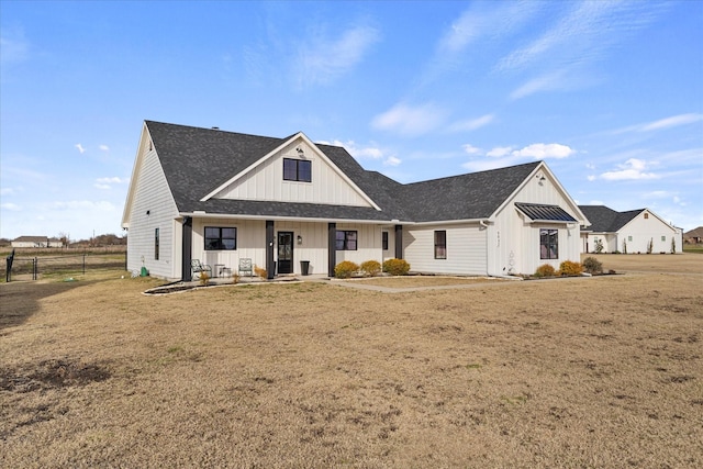 modern inspired farmhouse featuring covered porch and a front lawn