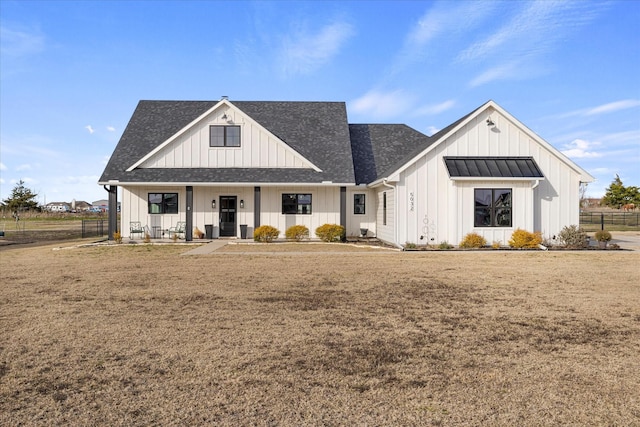 modern inspired farmhouse with covered porch and a front yard