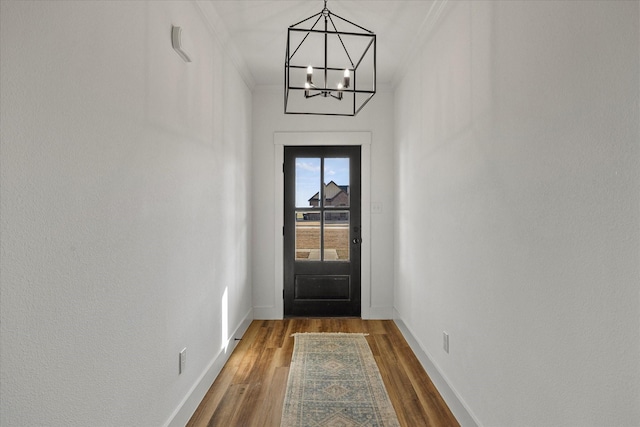 entryway featuring ornamental molding, hardwood / wood-style floors, and an inviting chandelier