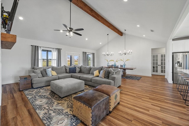 living room featuring hardwood / wood-style flooring, french doors, high vaulted ceiling, ceiling fan with notable chandelier, and beamed ceiling