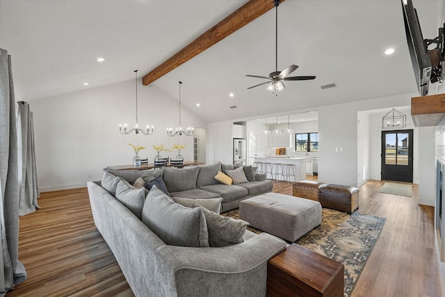 living room with ceiling fan with notable chandelier, high vaulted ceiling, hardwood / wood-style floors, and beamed ceiling