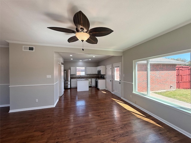 unfurnished living room featuring baseboards, visible vents, a ceiling fan, dark wood-style flooring, and crown molding