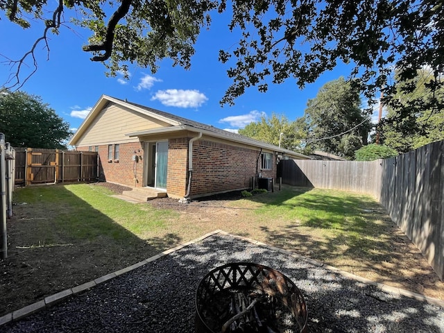 back of property with a yard and an outdoor fire pit