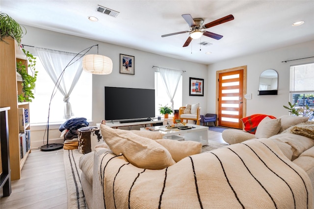 living room featuring ceiling fan, light hardwood / wood-style flooring, and a wealth of natural light