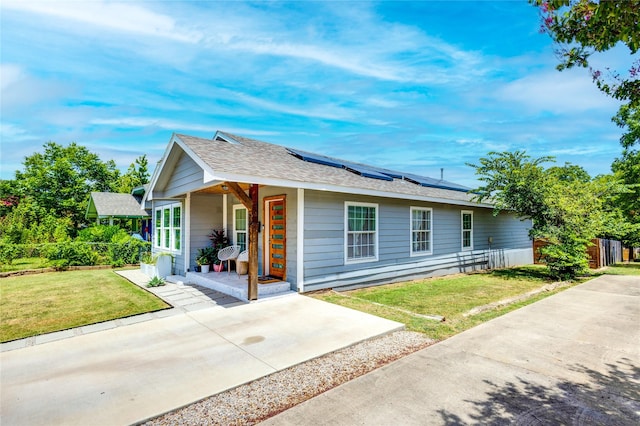 ranch-style house featuring solar panels, a porch, and a front yard