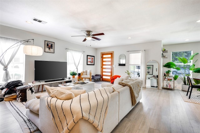 living room featuring ceiling fan and light hardwood / wood-style floors