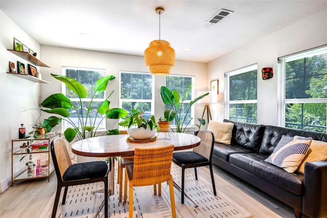 dining area with light wood-type flooring and a wealth of natural light