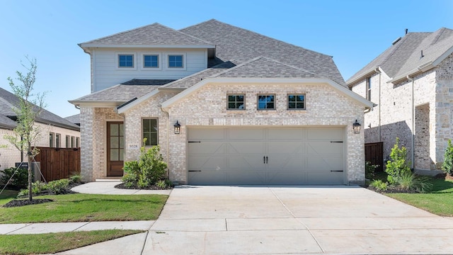 9328 Paintbrush Dr, Oak Point, TX 75068 - french country style house featuring a shingled roof, concrete driveway, brick siding, and an attached garage