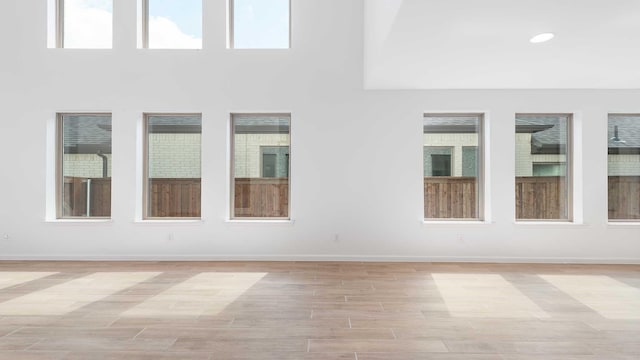 9328 Paintbrush Dr, Oak Point, TX 75068 - empty room featuring light wood-style floors, baseboards, and a towering ceiling