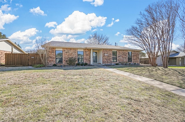 ranch-style house featuring brick siding, a front yard, and fence