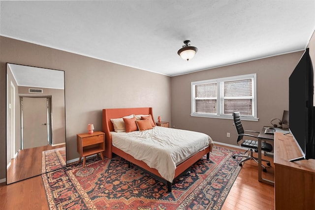 bedroom with light wood-style flooring, visible vents, and baseboards