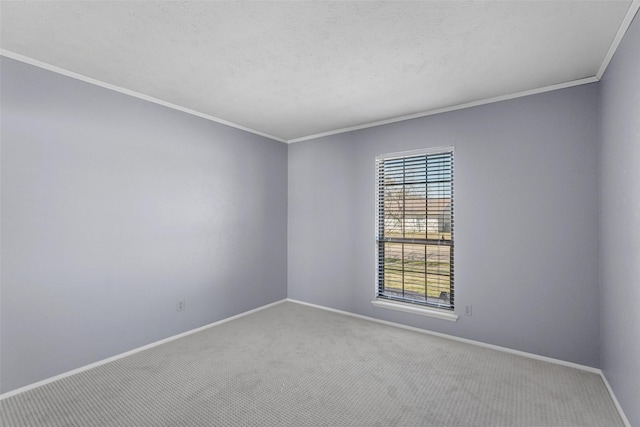 carpeted empty room featuring ornamental molding, a textured ceiling, and baseboards