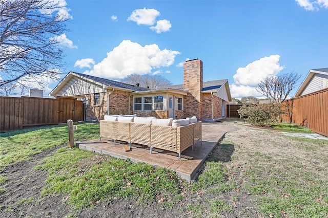 rear view of property featuring brick siding, a chimney, outdoor lounge area, a lawn, and a fenced backyard