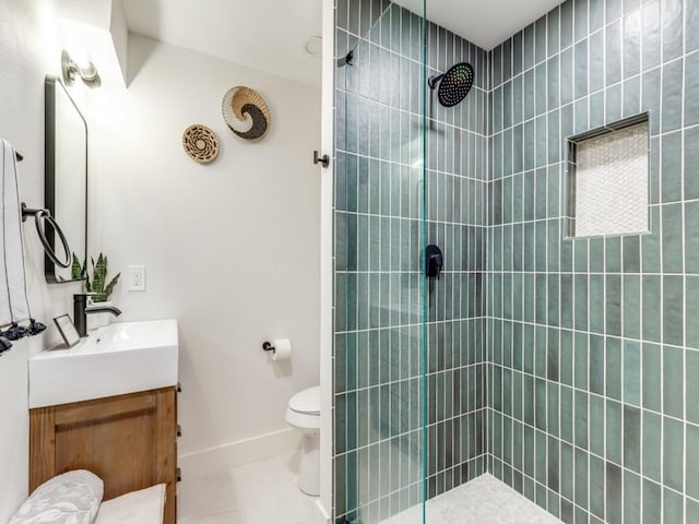 bathroom featuring tile patterned flooring, a tile shower, vanity, and toilet