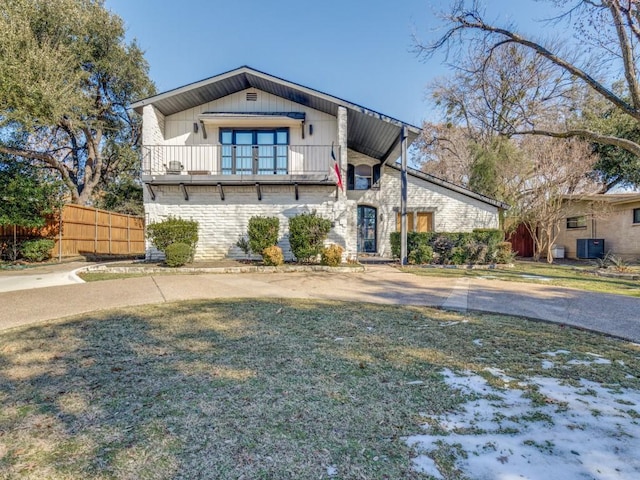 view of front of property featuring cooling unit, a balcony, and a front lawn