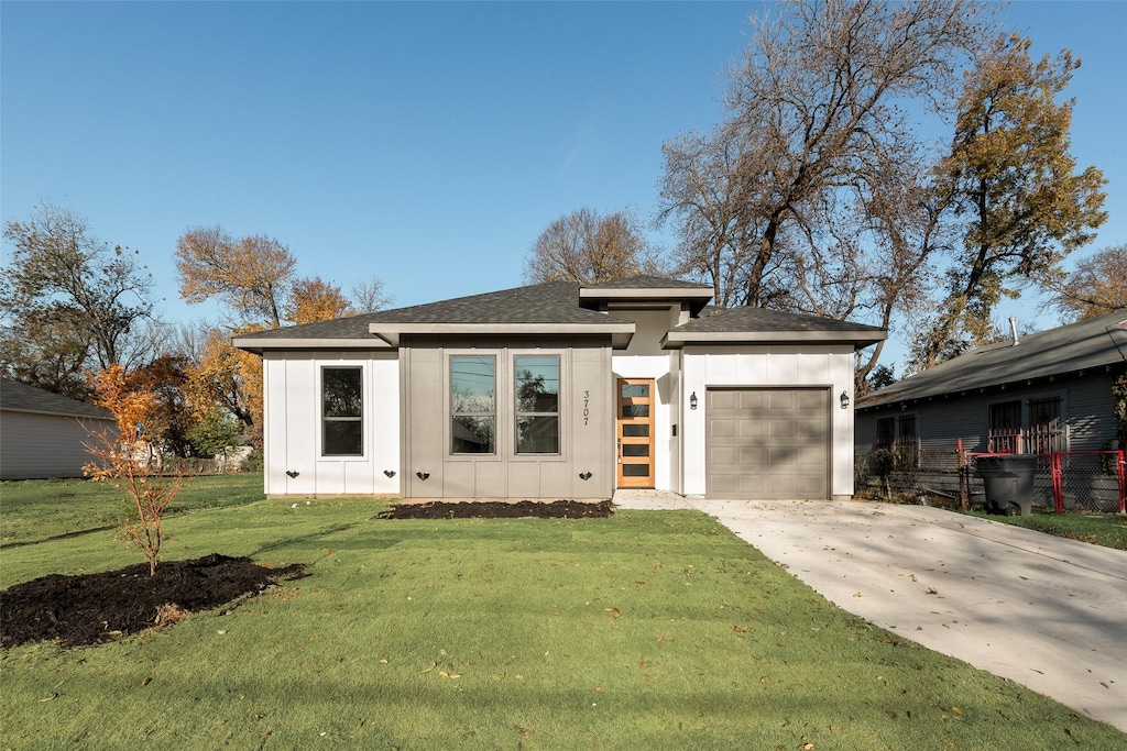 view of front of home featuring a front lawn and a garage