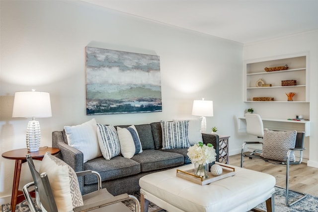 living room with light wood-type flooring and crown molding