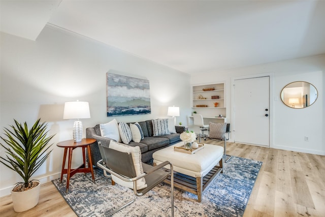 living room with built in features and light hardwood / wood-style flooring