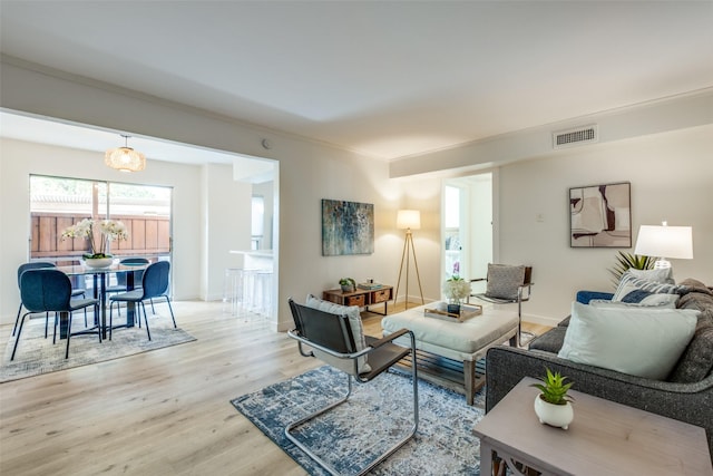 living room featuring ornamental molding and light hardwood / wood-style flooring