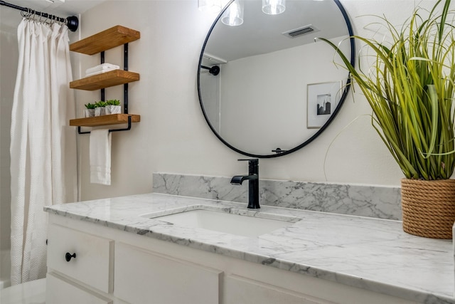 bathroom with walk in shower and vanity