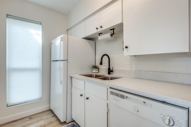 kitchen featuring sink, white cabinets, light stone counters, white appliances, and light hardwood / wood-style flooring