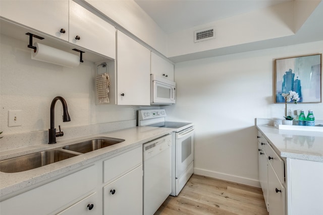 kitchen featuring sink, white cabinetry, white appliances, light wood-type flooring, and light stone countertops