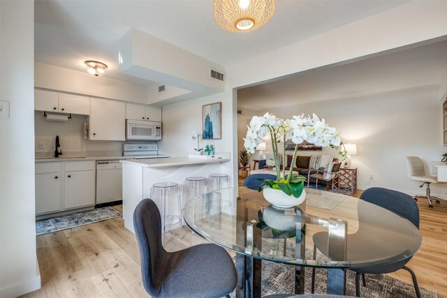 dining area with sink and light wood-type flooring