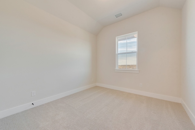 unfurnished room with lofted ceiling and carpet floors