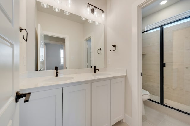 bathroom with toilet, vanity, tile patterned flooring, and plenty of natural light