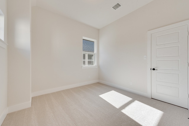 spare room featuring light colored carpet