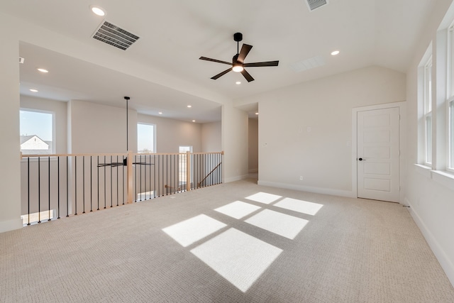 unfurnished room featuring vaulted ceiling, light colored carpet, and ceiling fan