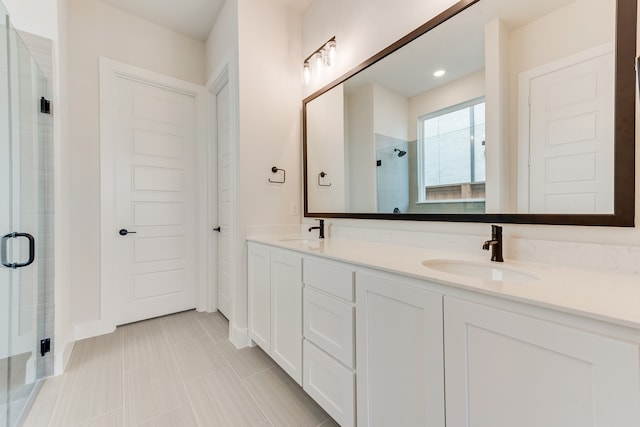 bathroom featuring a shower with door, tile patterned floors, and vanity