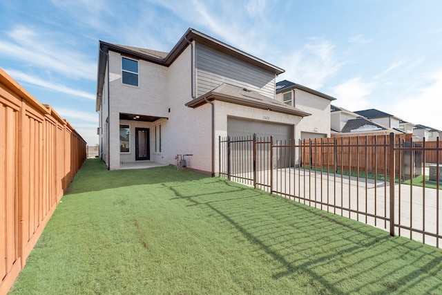 back of property featuring a yard, a patio area, and a garage