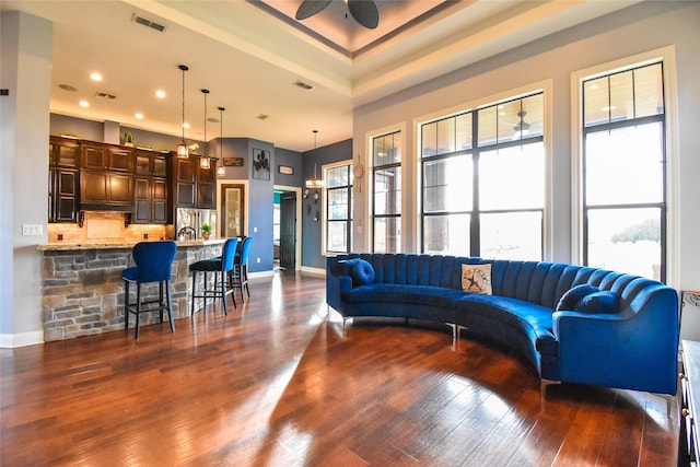 living room featuring a high ceiling, ceiling fan, a wealth of natural light, and dark hardwood / wood-style floors