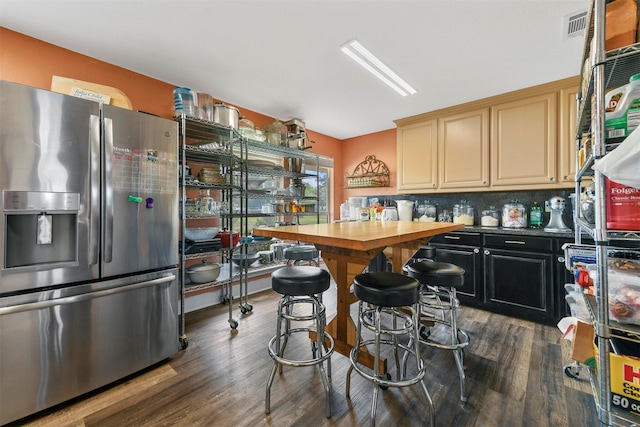 kitchen with butcher block countertops, dark hardwood / wood-style floors, backsplash, and stainless steel fridge